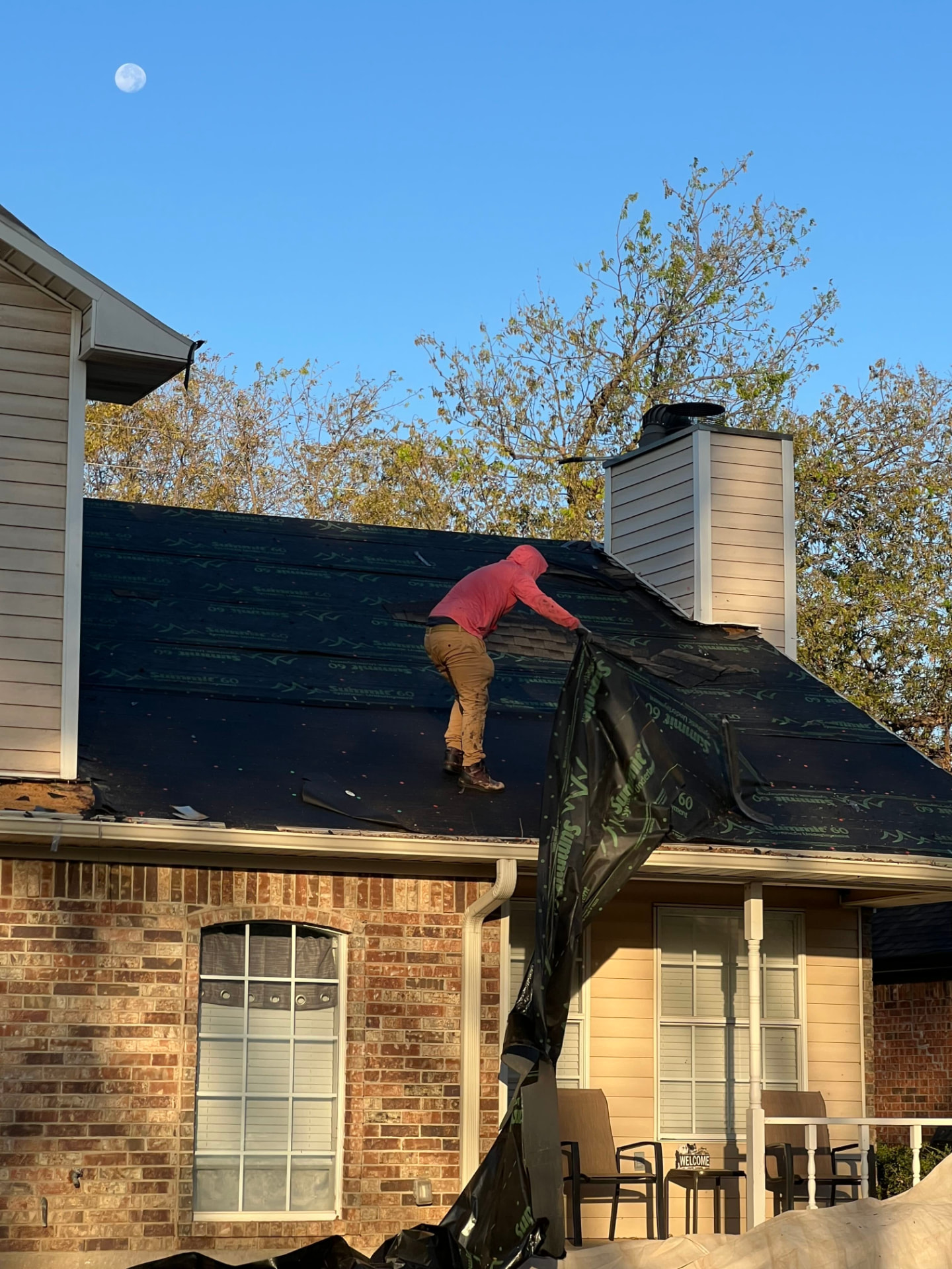 Worker installing underlayment on a residential roof